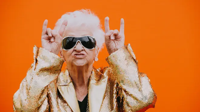 Grandmother poses with sunglasses and devil horns up