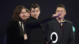 Alex Turner of the Arctic Monkeys on stage after winning Best British Group during the 2014 Brit Awards