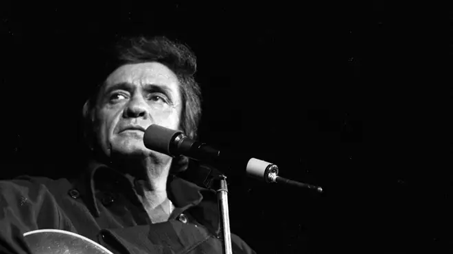 Country singer/songwriter Johnny Cash plays acoustic guitar as he performs onstage at the Anaheim Convention Center on March 11, 1978