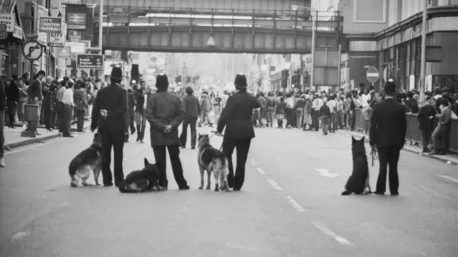 Police dog handlers on Atlantic Road on the second day of riots in Brixton, South London, 13th April 1981. (