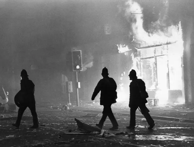 Toxteth Riot 6th July 1981 Police officers in riot gear outside a burning looted shop in Park Road.