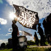 A woman holds a Black Lives Matter flag during an event in remembrance of George Floyd, 24 May 2021