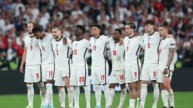 The England players look on from the half way line as Harry Maguire steps up to take England's second penalty.