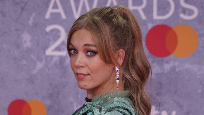 Becky Hill poses on the red carpet upon her arrival for the BRIT Awards 2022