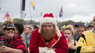 A man dressed as Father Christmas waits for Royal Blood to perform on the Pyramid Stage at Glastonbury Festival 2017