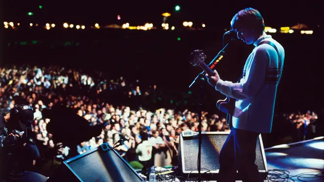 Noel Gallagher onstage with Oasis at Knebworth, August 1996