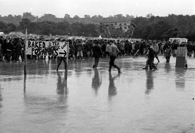 A view of festival-goers covered in mud at a rain-soaked Glastonbury Festival 1997