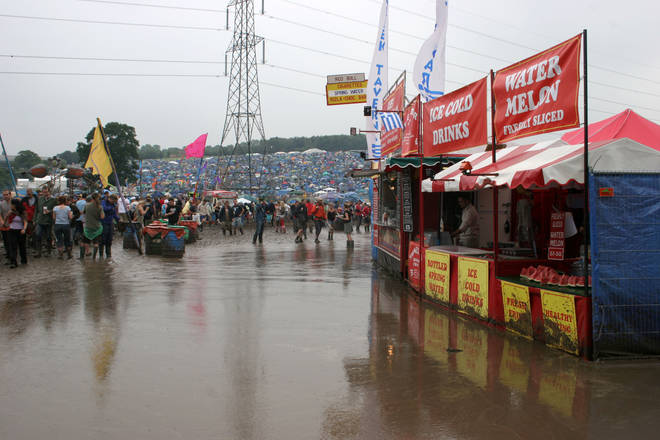 The market stalls try and shore up against the flash floods at Glastonbury 2005