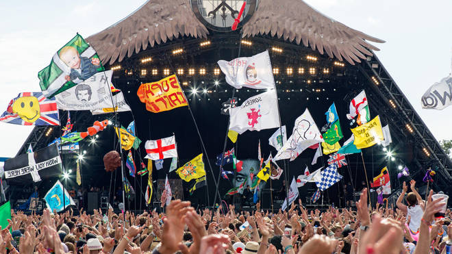 Flags fly in front of the Pyramid Stage at Glastonbury 2015