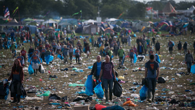 Litter pickers clear the rubbish left in front of the main Pyramid Stage, 2014