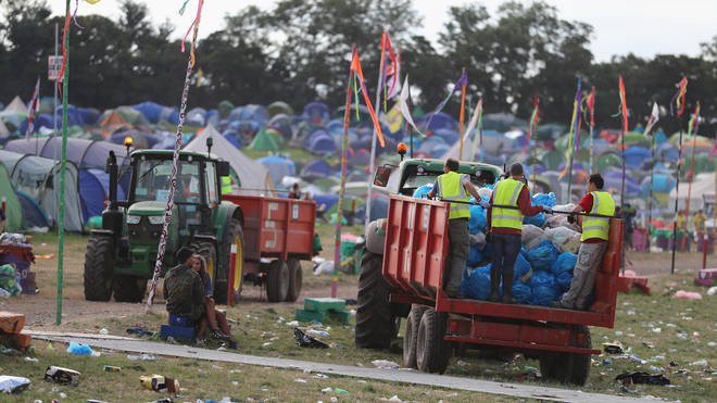 Litter pickers begin the job of clearing the fields at the Glastonbury Festival site, 2017