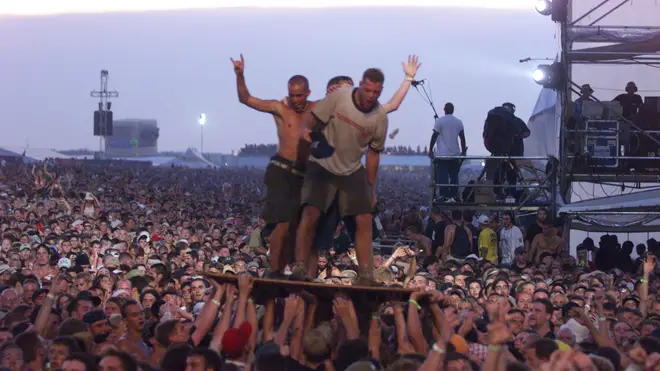 Members of the crowd go plywood surfing during Limp Bizkit's set at Woodstock '00