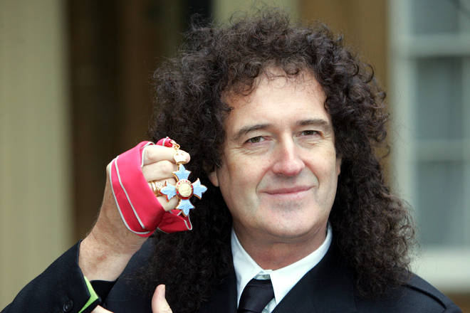 Brian May holds his CBE medal at Buckingham Palace in London in 2005
