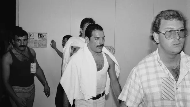 Freddie Mercury backstage at the Live Aid concert at Wembley, 13th July 1985. On the left is his partner Jim Hutton.