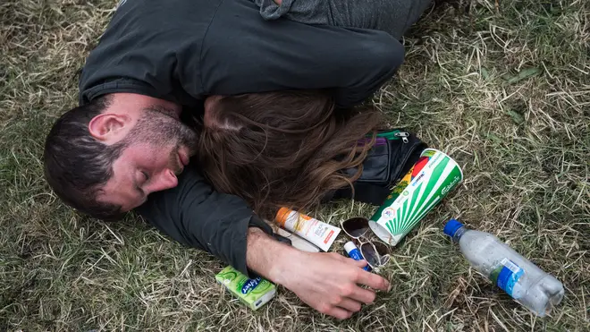 A couple fall asleep on the grass at Glastonbury Festival 2017