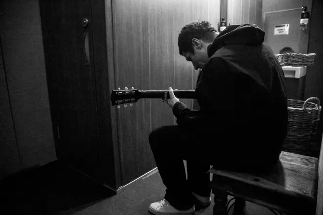 Liam Gallagher plays guitar backstage in the As It Was film documentary