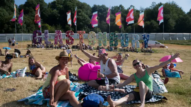 Glastonbury Festival goers behind the Glastonbury sign in 2017