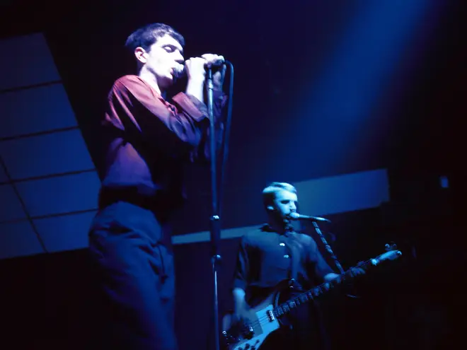 Joy Division in October 1979:  Ian Curtis and Peter Hook performing live onstage at London's Electric Ballroom