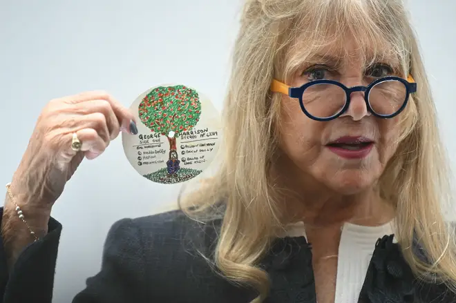 attie Boyd holds an original design doodle for an Apple records LP label by late English musician and Beatles member George Harrison