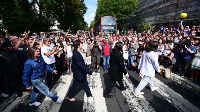 Beatles impersonators recreate the iconic 'Abbey Road' photograph made 50 years ago today, on August 8, 2019 in London