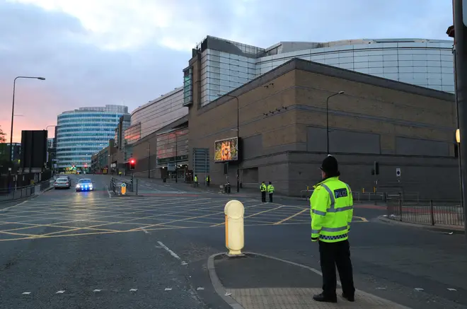 A police officer guards the area outside Manchester Arena the day after the 22 May 2017 attack