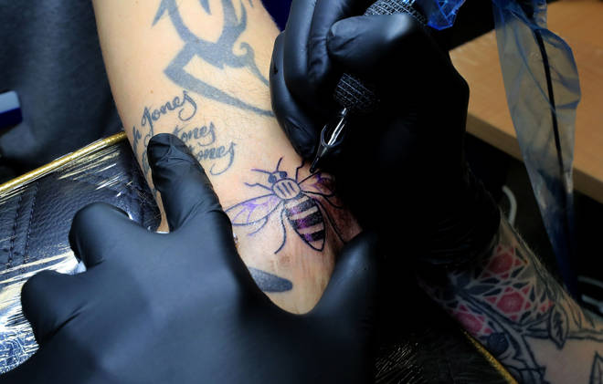 Staff members at Northern Rail receive a bee tattoo in memory of the victims of the Manchester Arena terror attack in 2017