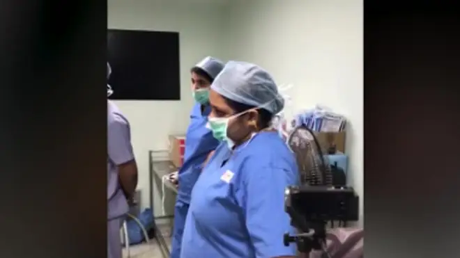 Medical staff look on as musician Abhishek Prasad plays guitar during brain surgery