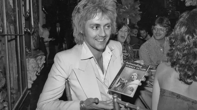 Roger Taylor receives a copy of Astounding Science Fiction during a party thrown for Queen by Elektra Records, 1977.